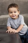Bambino appoggiato su una sedia marrone — Foto stock