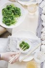 Frau verwendet Essstäbchen, um Gemüse zu essen — Stockfoto