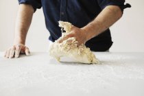 Baker kneading and shaping dough — Stock Photo