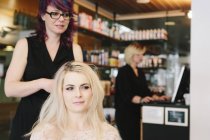 Hair stylist and client at salon — Stock Photo