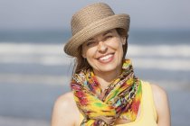 Женщина в шляпе и шарфе на пляже — стоковое фото