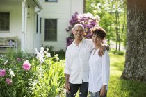 Mature couple standing together among flowers — Stock Photo
