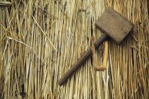 Деревянный молоток и колышек на соломе — стоковое фото