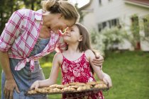 Девушка держит поднос со свежим печеньем — стоковое фото