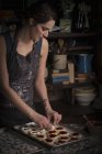 Женщина на кухне с подносом для выпечки печенья — стоковое фото