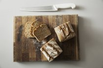 Baked loaf of bread and slices — Stock Photo