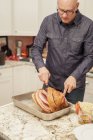 Man carving a joint of cooked ham — Stock Photo