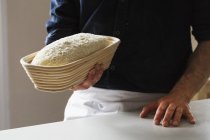 Baker segurando um pão recém-assado — Fotografia de Stock