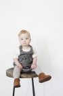 Girl sitting on tall stool — Stock Photo