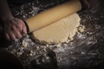 Woman rolling out dough with rolling pin — Stock Photo
