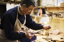 Uomo che lavora su un pezzo di legno — Foto stock