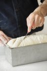 Baker cutting bread dough — Stock Photo
