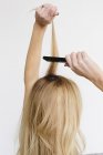 Donna con i capelli biondi utilizzando pettine — Foto stock