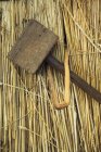 Wooden mallet and peg on straw — Stock Photo