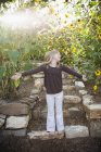 Ребенок, стоящий на садовой дорожке — стоковое фото
