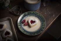 Teller mit herzförmigem Keks und Himbeeren — Stockfoto