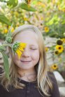 Girl with sun flower in front of eye — Stock Photo