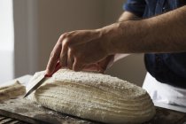 Пекар нарізає свіжоспечений хліб — стокове фото