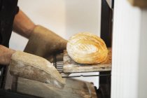 Padeiro tirando pão de um forno . — Fotografia de Stock
