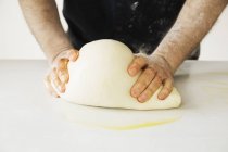 Пекарь месит большое хлебное тесто . — стоковое фото