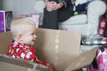 Niño sentado en una caja de cartón grande - foto de stock