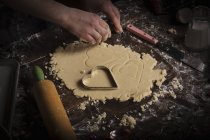 Жінка вирізає печиво у формі серця — стокове фото
