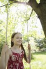 Girl in sundress on swing — Stock Photo