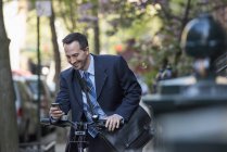 Uomo d'affari seduto sulla bicicletta — Foto stock