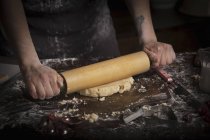 Женщина выкатывает тесто скалкой — стоковое фото