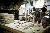 Homme travaillant dans un atelier de fabrication de meubles — Photo de stock