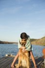 Girl cuddling a golden retriever dog. — Stock Photo