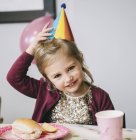 Ragazza con un cappello da festa a una festa di compleanno . — Foto stock