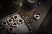 Baking tray with heart shaped biscuits — Stock Photo