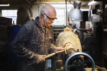 Homme avec machine à bois dans un atelier de menuiserie — Photo de stock