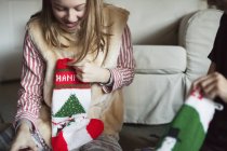 Люди розпаковують різдвяні панчішні подарунки — стокове фото