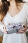 Woman holding package with large ribbon — Stock Photo