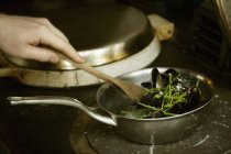 Chef brassant des moules noires — Photo de stock