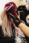 Colorista del pelo aplicando color rosa - foto de stock