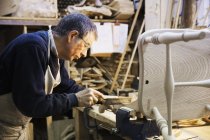 Человек, работающий на деревянном стуле — стоковое фото