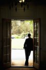 Silhouette of a man standing in a doorway — Stock Photo