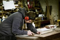 Hombre que trabaja en el taller de un fabricante de muebles - foto de stock