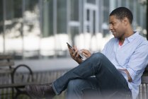 Mann sitzt mit Tablet auf Bank — Stockfoto