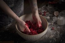 Woman preparing fresh raspberries in bowl — Stock Photo