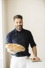 Пекарь держит хлеб — стоковое фото