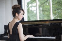 Donna che suona su un pianoforte a coda — Foto stock