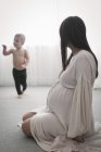 Heavily pregnant woman playing with son — Stock Photo