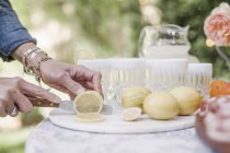 Женщина режет лимоны для напитка . — стоковое фото
