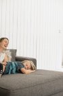 Mother and son lying on sofa — Stock Photo