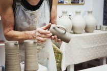 Potter handling a wet clay pot — Stock Photo