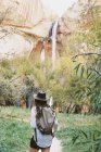 Donna con zaino sotto una scogliera alta — Foto stock